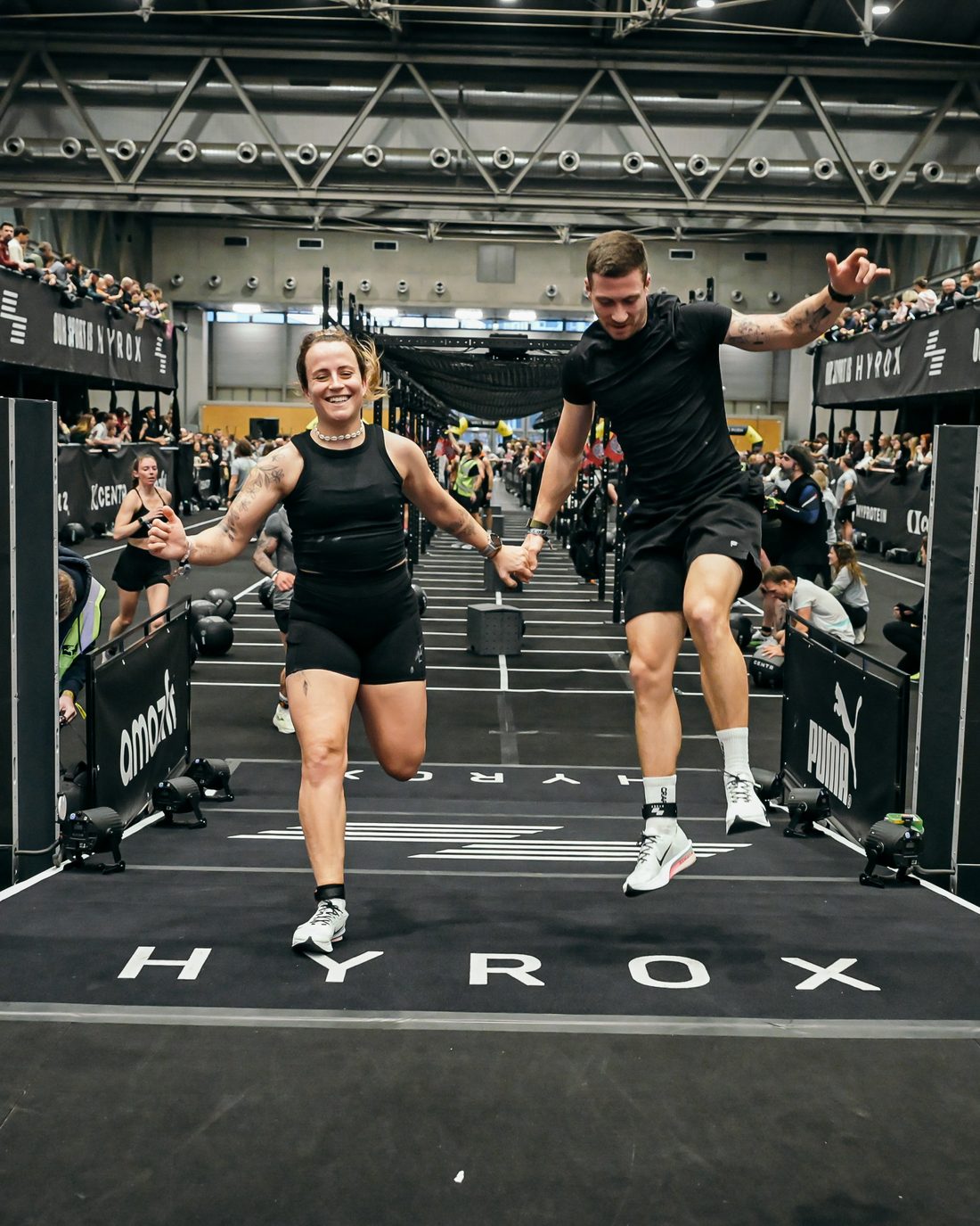 Nina und Nico Hand in Hand im Ziel eines Hyrox-Wettkampfs